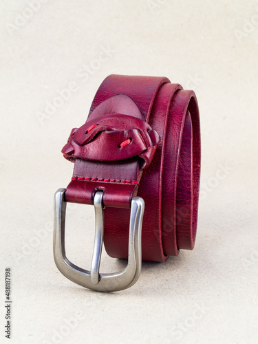 A leather belt with a clasp lies neatly on the table