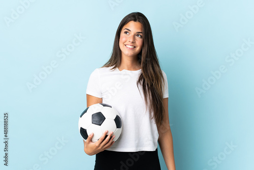 Young football player brazilian girl isolated on blue background thinking an idea while looking up © luismolinero