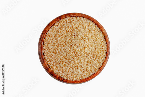 Sesame seeds in a wooden bowl, on a white background photo