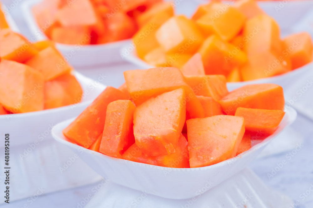 Slices of Papaya fruit - served on small white plates are a popular steet food of local people pf Kolkata. West Bengal - India Slices of Papaya fruit - served on small white plates are a popular steet food of local people pf Kolkata. West Bengal - India