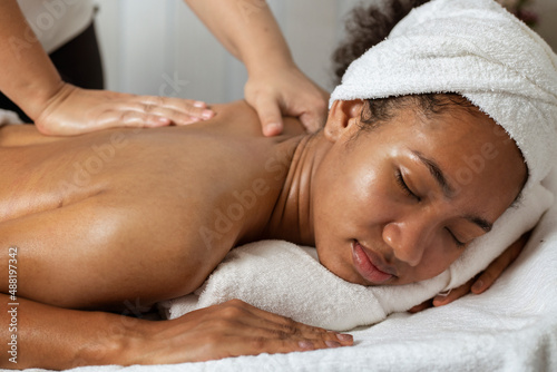 Beautiful woman enjoying back massage with closed eyes. Spa treatment concept