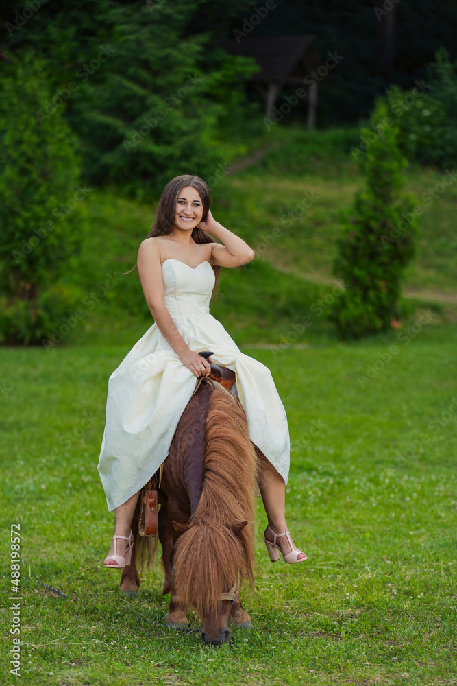 Fototapeta premium girl riding a pony in the park
