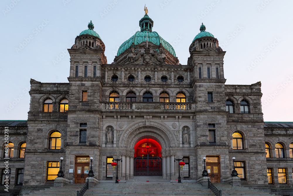 The 1897 British Columbia Parliament building’s main entrance seen at dusk with red lanterns hanging to highlight the Chinese New Year, Victoria, BC, Canada
