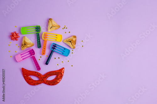 Billede på lærred Purim holiday background with carnival mask, noisemaker and hamantaschen cookies