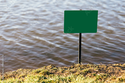 Mocap image - green sign for fishing on the lake. Place for text.