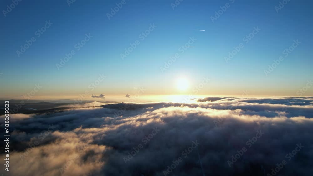 Flying trough clouds towards the sun. Magical moment of sun rising above the clouds. 