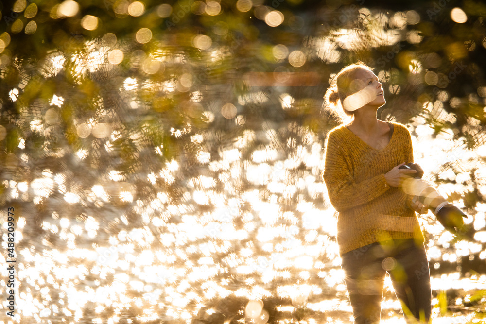 Pretty, female photographer taking pictures outdoor on a lovely autumn day - shallow DOF, color toned image Pretty, female photographer taking pictures outdoor on a lovely autumn day - shallow DOF, color toned image