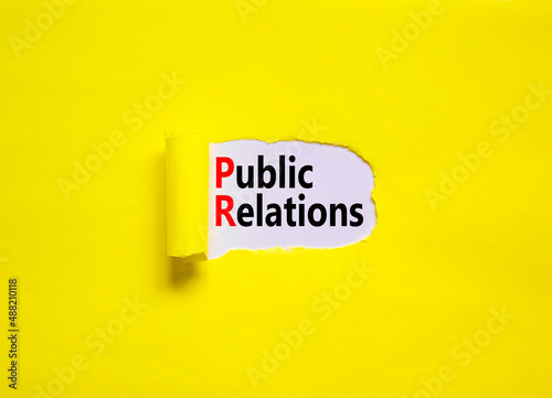 PR public relations symbol. Concept words PR public relations on yellow paper on a beautiful yellow table white background, copy space. Business and PR public relations concept.