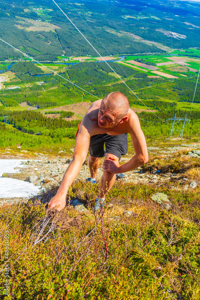 Naklejka premium Extreme hiker hikes climbs in snow in summer Hemsedal Norway.