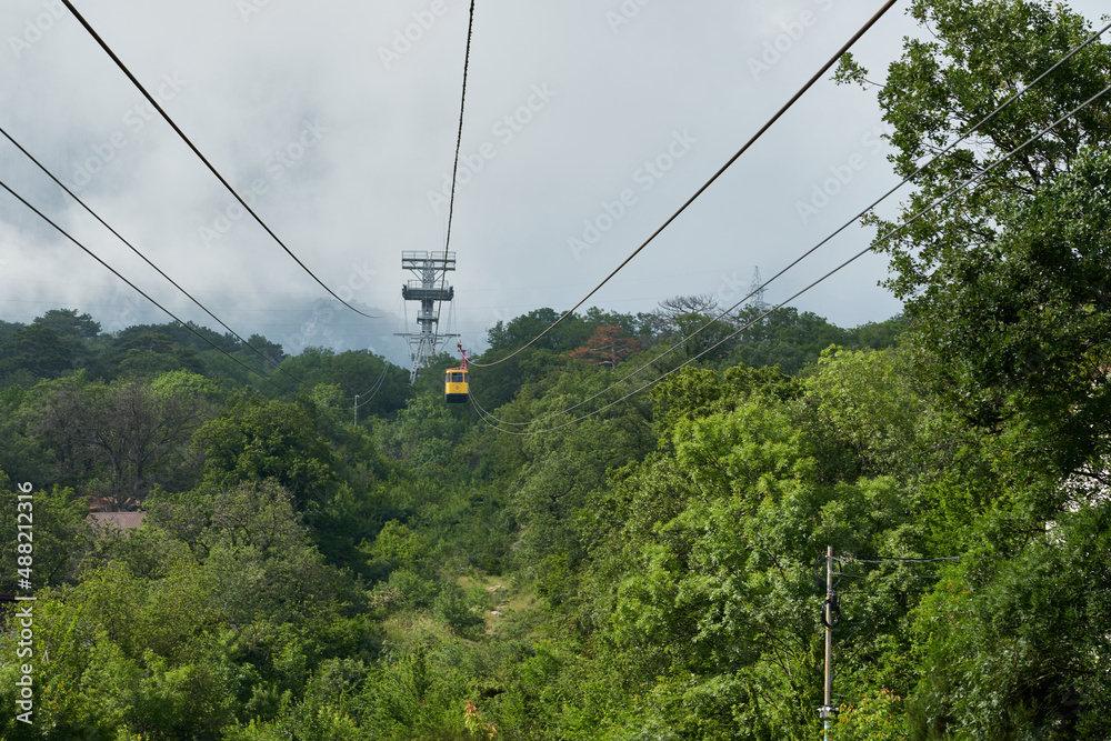 Suspended cable car to the mountain peaks covered with clouds