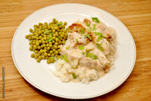 Pork with Cream Sauce Over White Rice & a Side Dish of Peas 