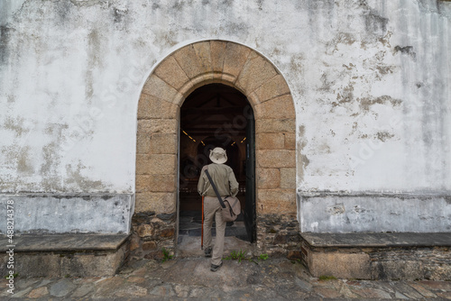 Pilgrim with hat, bag and cane in Church on the Camino de Santiago. Way of St James © Joe McUbed