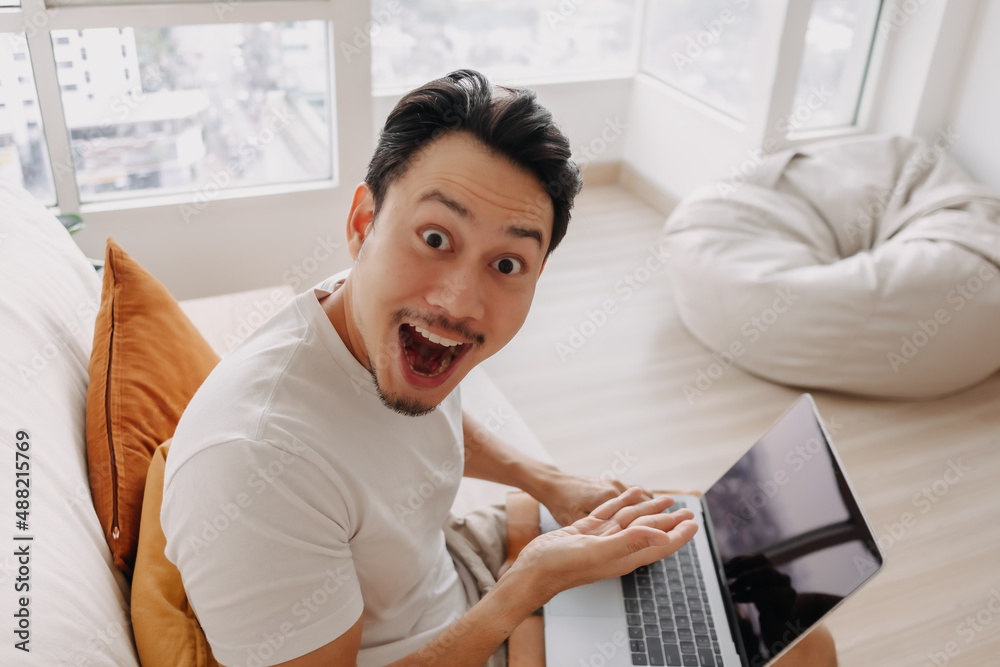 Surprised and wow face of Asian man happy with the result in his tablet. Surprised and wow face of Asian man happy with the result in his tablet.
