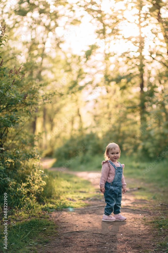 A little girl walks along the footpath on a clear, sunny summer day. A little girl walks along the footpath on a clear, sunny summer day.