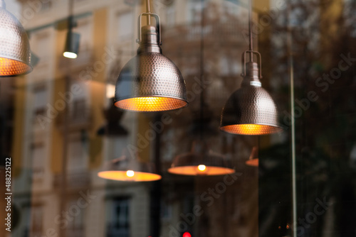 Spotlights with incandescent bulbs creating a warm atmosphere inside a restaurant.