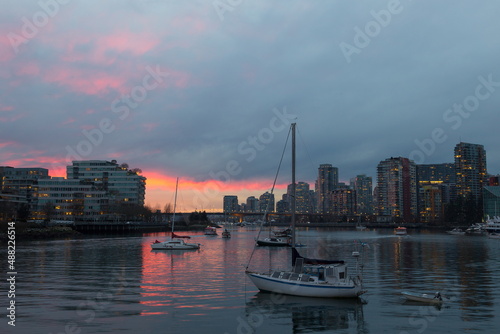 View of boats moored in False Creek seen during a beautiful blue hour sunset in winter, with cityscape in the background, Vancouver, British Columbia, Canada