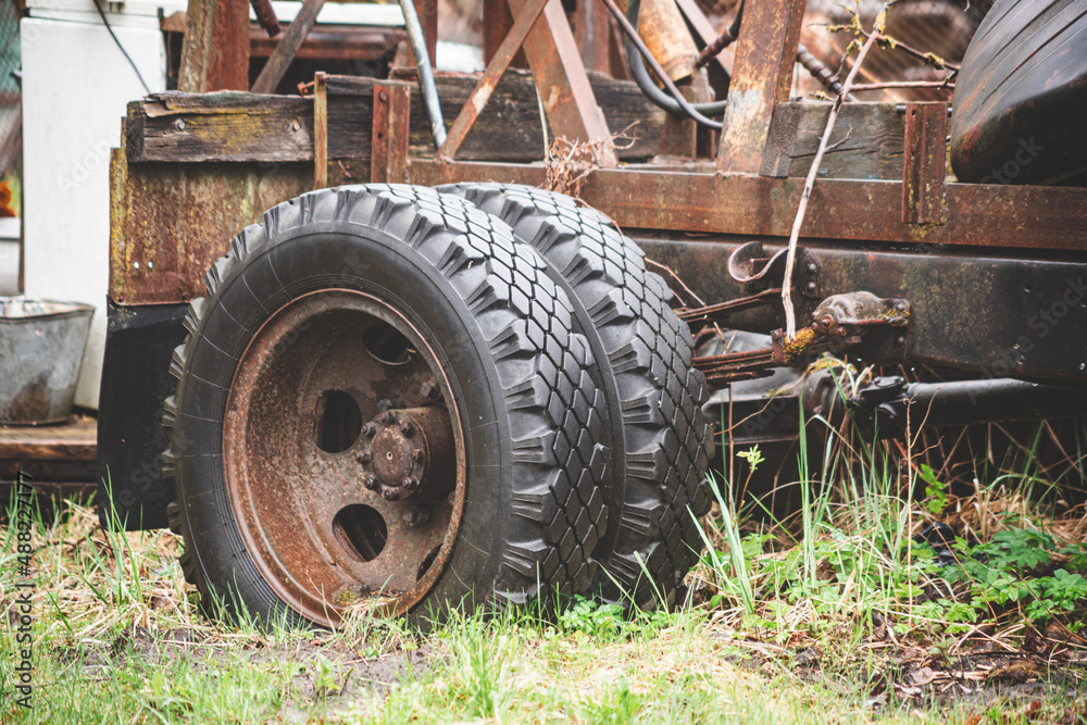 double wheel of old abandoned no more used car, rusty metal parts, growing in grass double wheel of old abandoned no more used car, rusty metal parts, growing in grass
