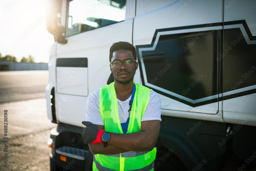 Young handsome African American man working in towing service and driving his truck.