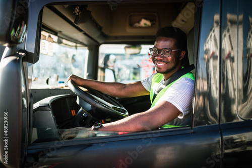 Young handsome African American man working in towing service and driving his truck. © hedgehog94