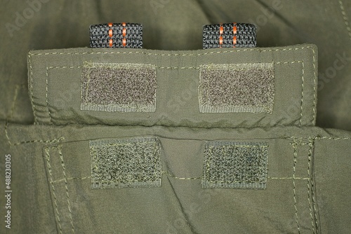 two green velcro on the fabric of the army clothing pocket