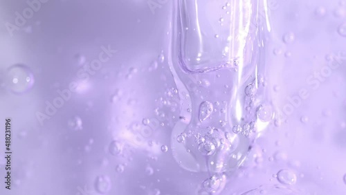 Bakuchiol serum transparent texture with dropper and slowly moving bubbles, purple liquid skincare cosmetic gel, macro shot.