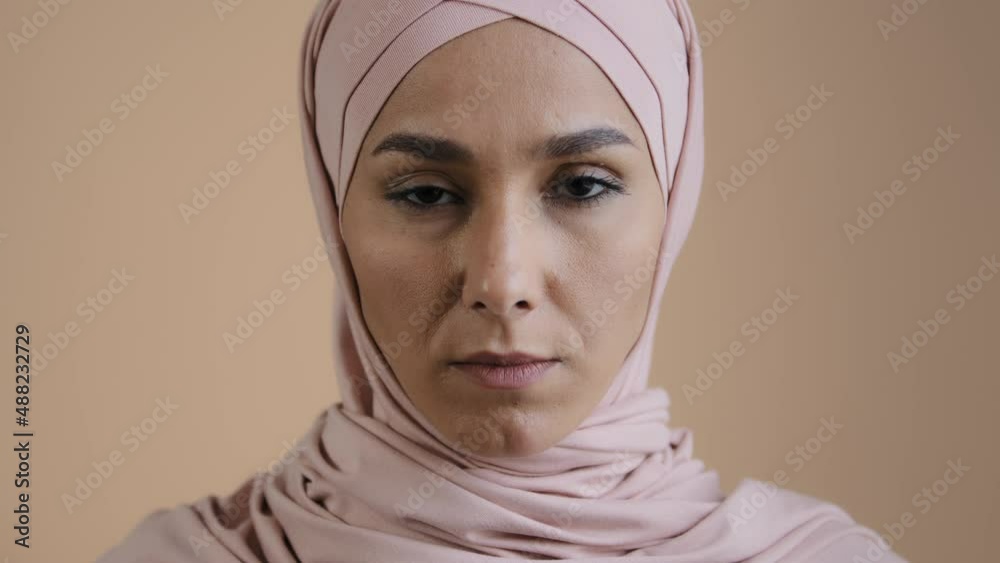 Close up face young girl in hijab traditional headscarf serious muslim woman looking at camera portrait of pensive upset posing female in studio offended islamic arabian lady religious discrimination Close up face young girl in hijab traditional headscarf serious muslim woman looking at camera portrait of pensive upset posing female in studio offended islamic arabian lady religious discrimination