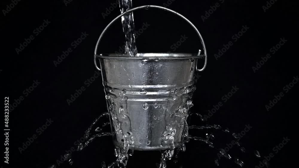 tin bucket with holes on black, slow motion