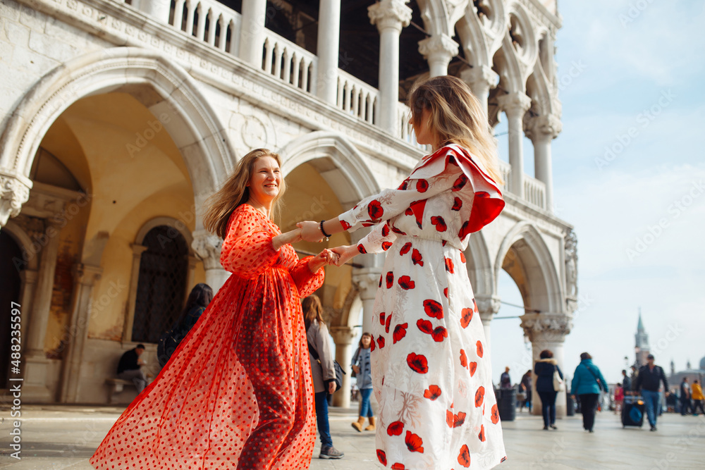 Obraz premium Mom and daughter in fashionable dresses walk around Venice. Lifestyle, travel, tourism.