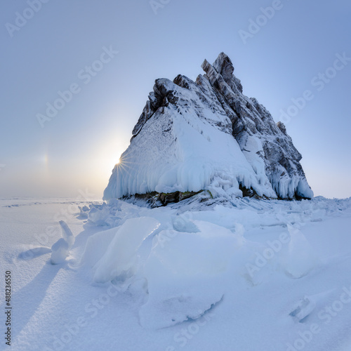 Lonely rock - an island on Lake Baikal under a layer of ice and snow