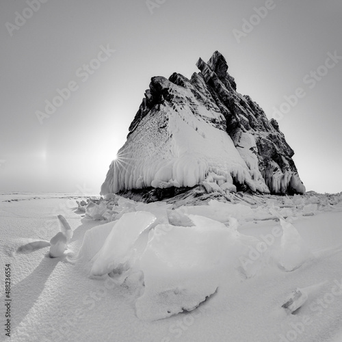 Lonely rock - an island on Lake Baikal under a layer of ice and snow