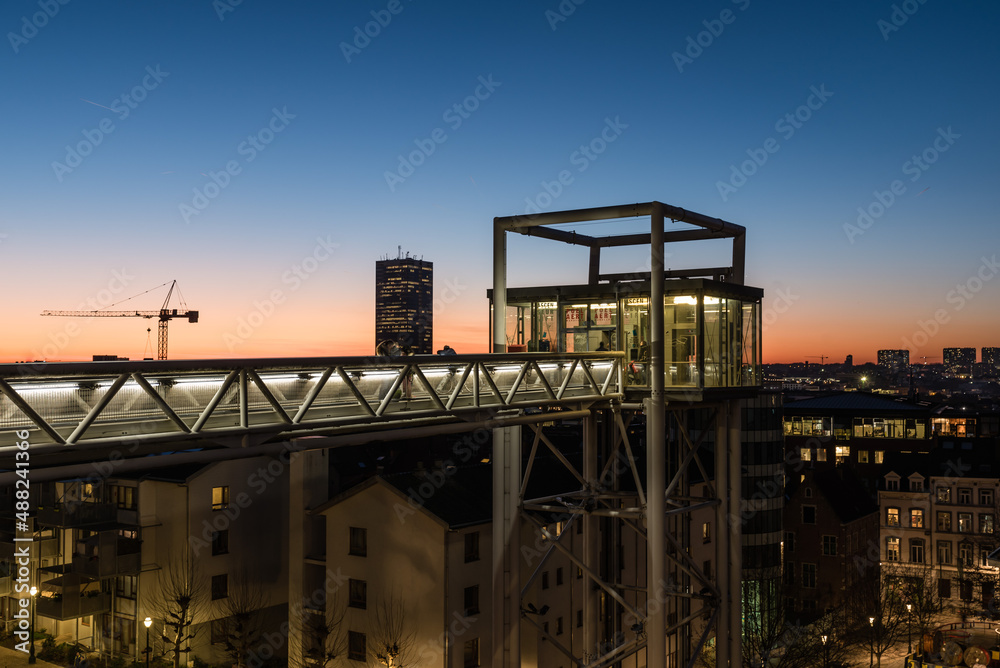 Brussels, Belgium - Tourist on the Poelaert pedestrian bridge, overlooking a colorful cityscape