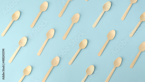 Wooden spoons, top view of wooden spoons isolated on blue background.