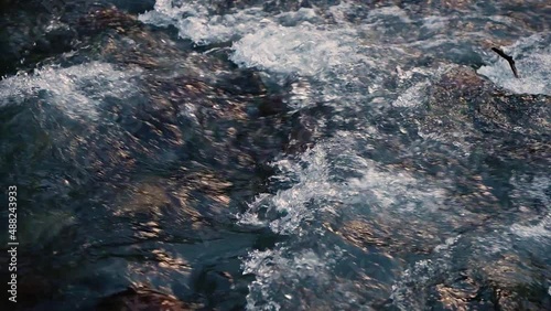 Slow motion of Norwegian mountain river , stream flowing through rocks. Close up of river stones with flowing water, clean water flowing in a mountain river at the Norway