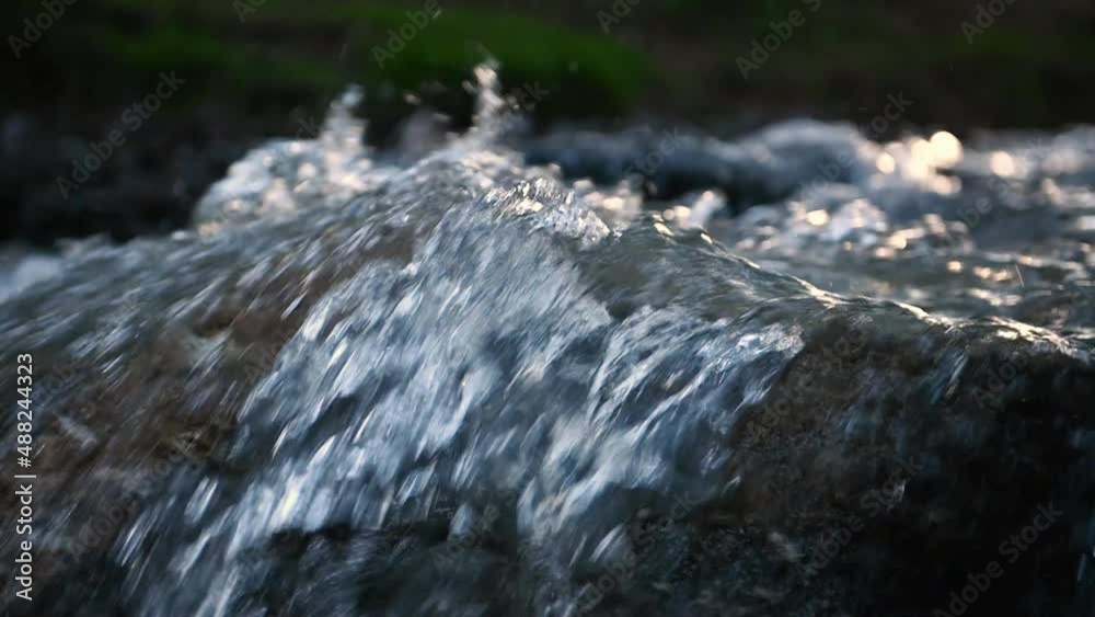 Slow motion of Norwegian mountain river , stream flowing through rocks. Close up of river stones with flowing water, clean water flowing in a mountain river at the Norway