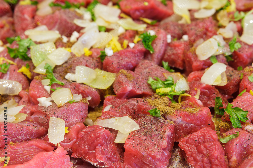 Raw meat with onion and spice ready for cooking, beef chopped into chunks Raw meat with onion and spice ready for cooking, beef chopped into chunks