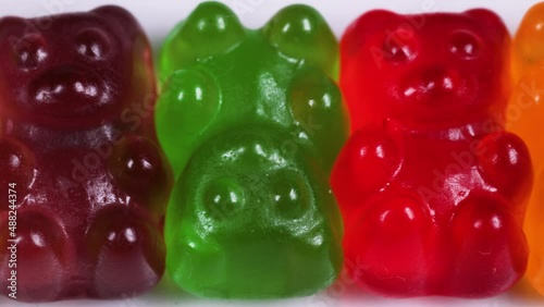 Macro view slider shot of colorful gummy bear shaped candies.candy background. Colorful jelly sweets.candies texture pattern close up footage. photo