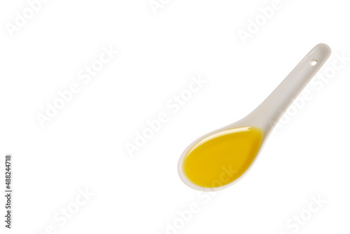 Tablespoon of olive oil, porcelain spoon with olive oil isolated on white background with space