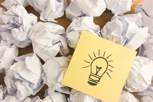 Light bulb drawing lying on crumpled office paper