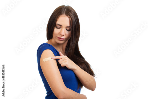 Cute young girl with a medical patch on her shoulder after vaccination. Isolated on white background. © Roman Rvachov
