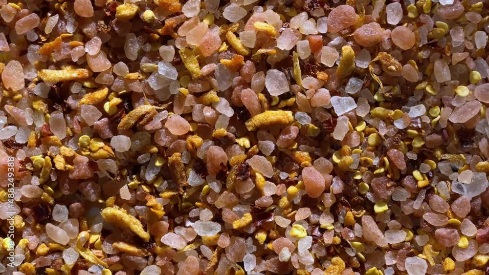 A blend of Himalayan pink salt with garlic and pepper rotates on the turntable. Food background A blend of Himalayan pink salt with garlic and pepper rotates on the turntable. Food background