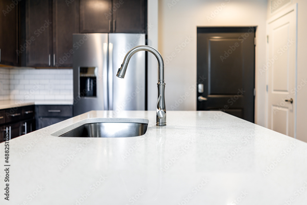 Kitchen room quartz countertop surface island in modern apartment home house by cabinets refrigerator fridge home appliance door entrance - obrazy, fototapety, plakaty 