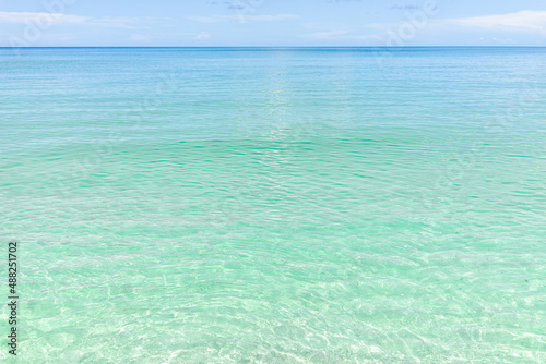 Beach in Naples in Southwest Florida with turquoise glass green idyllic water on summer day with blue sky coast horizon in paradise, nobody in landscape