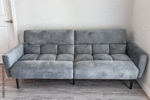 Living room interior with front view of futon couch gray sofa sofabed with microfiber velvet fabric in modern apartment home house photo