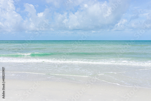 Beach in Naples in Southwest Florida with turquoise blue green idyllic water on summer day gulf of mexico coast horizon in paradise landscape nobody