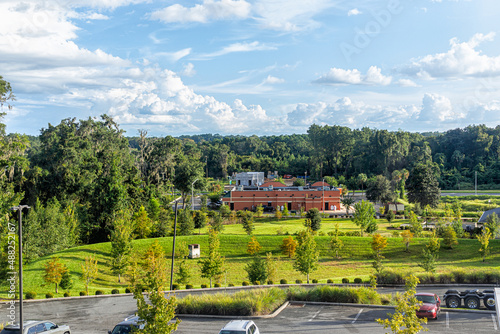 High angle view of summer landscape in Alachua, Florida near Gainesville with building cars parking lot and green trees with blue sky photo