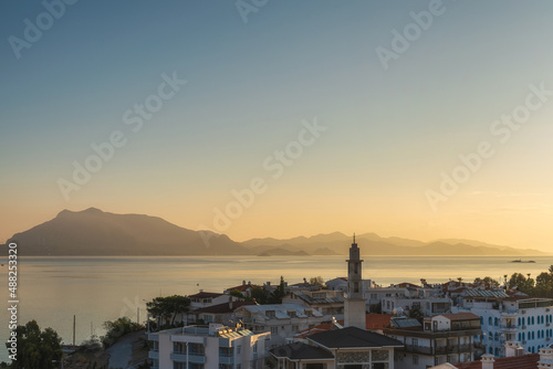 View on Datca town with harbor and island at sunrise, Mugla province, Turkey. Popular tourist summer destination