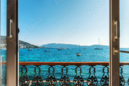 Fototapeta Naklejka Na Ścianę i Meble -  Window view from hotel on turquoise water of Aegean sea with yachts in Bodrum town, Mugla province, Turkey