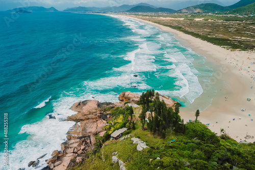 Joaquina beach and blue ocean with waves in Brazil. Aerial view