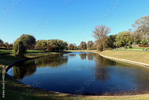 Pond and trees in the park on a warm autumn day. Kepa Potocka, Warsaw, Poland