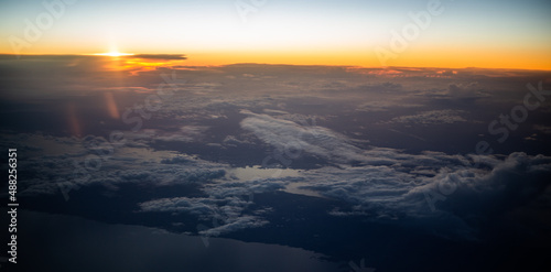 Aerial view from the plane to sunset over the shore